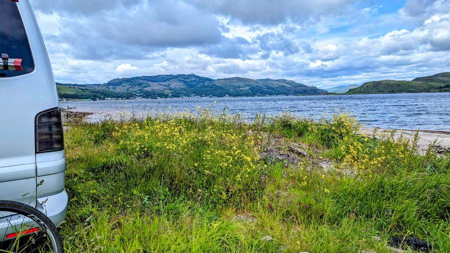 View across the Kyles of Bute from near Kames, with a campervan parked at the water's edge