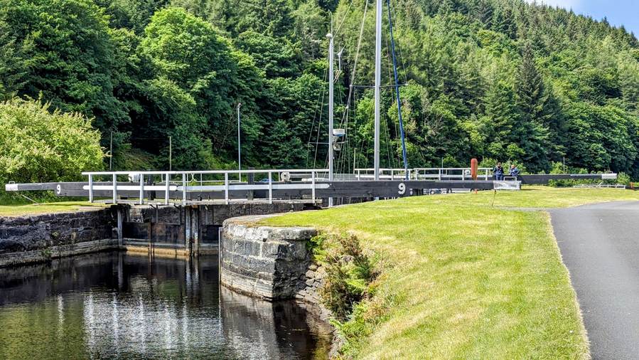 The Crinan Canal with lock gates and a bridge, seen from the towpath