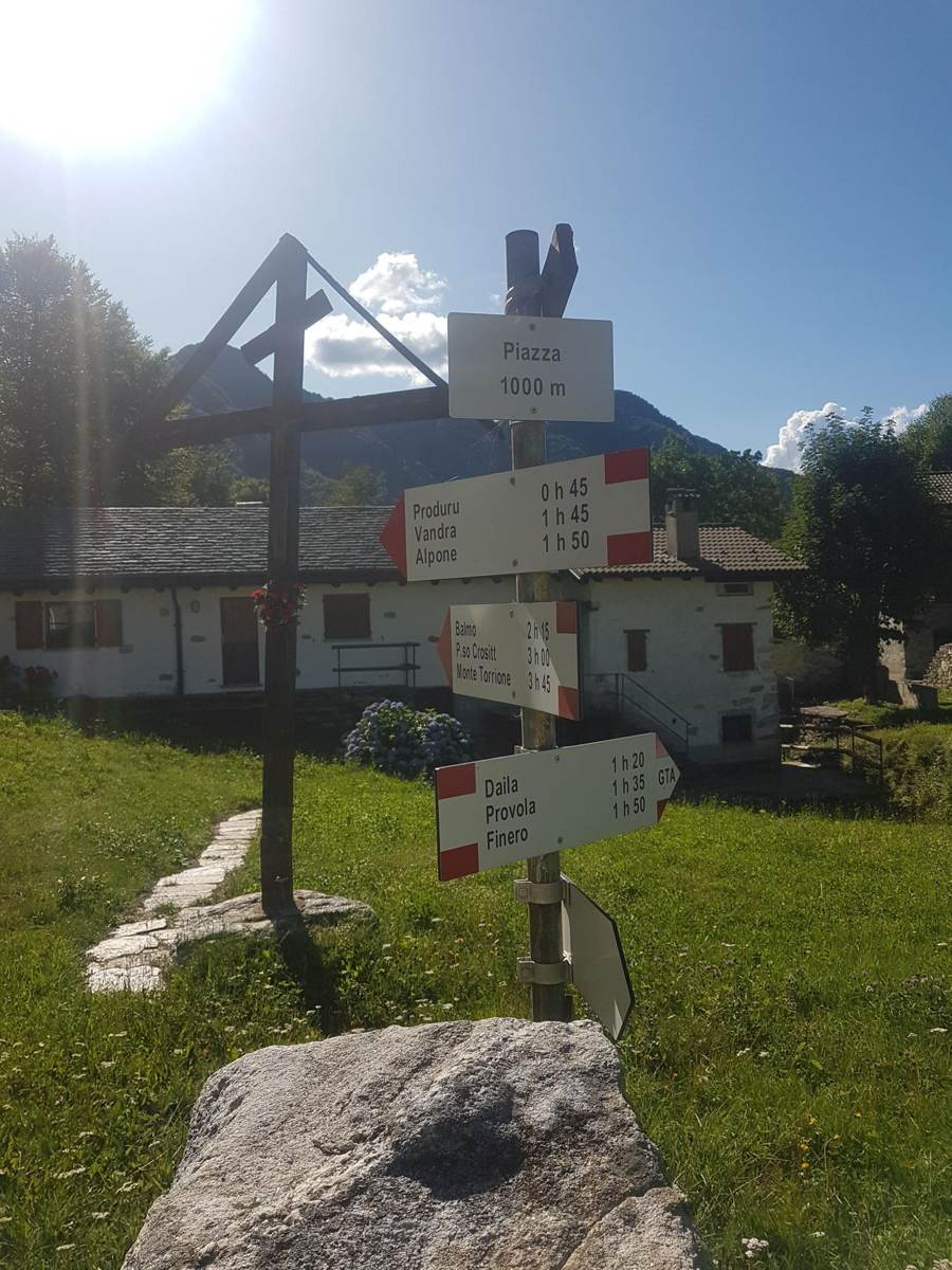 Wooden trail signpost with multiple route directions in the hills above Cannobio