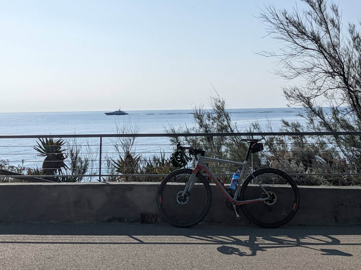 A road bike leaning against a railing overlooking the sea along the Ligurian coast path near Imperia