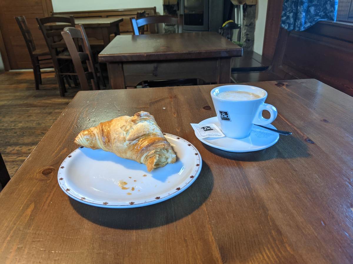 Coffee and a croissant at a café table in the Aosta Valley
