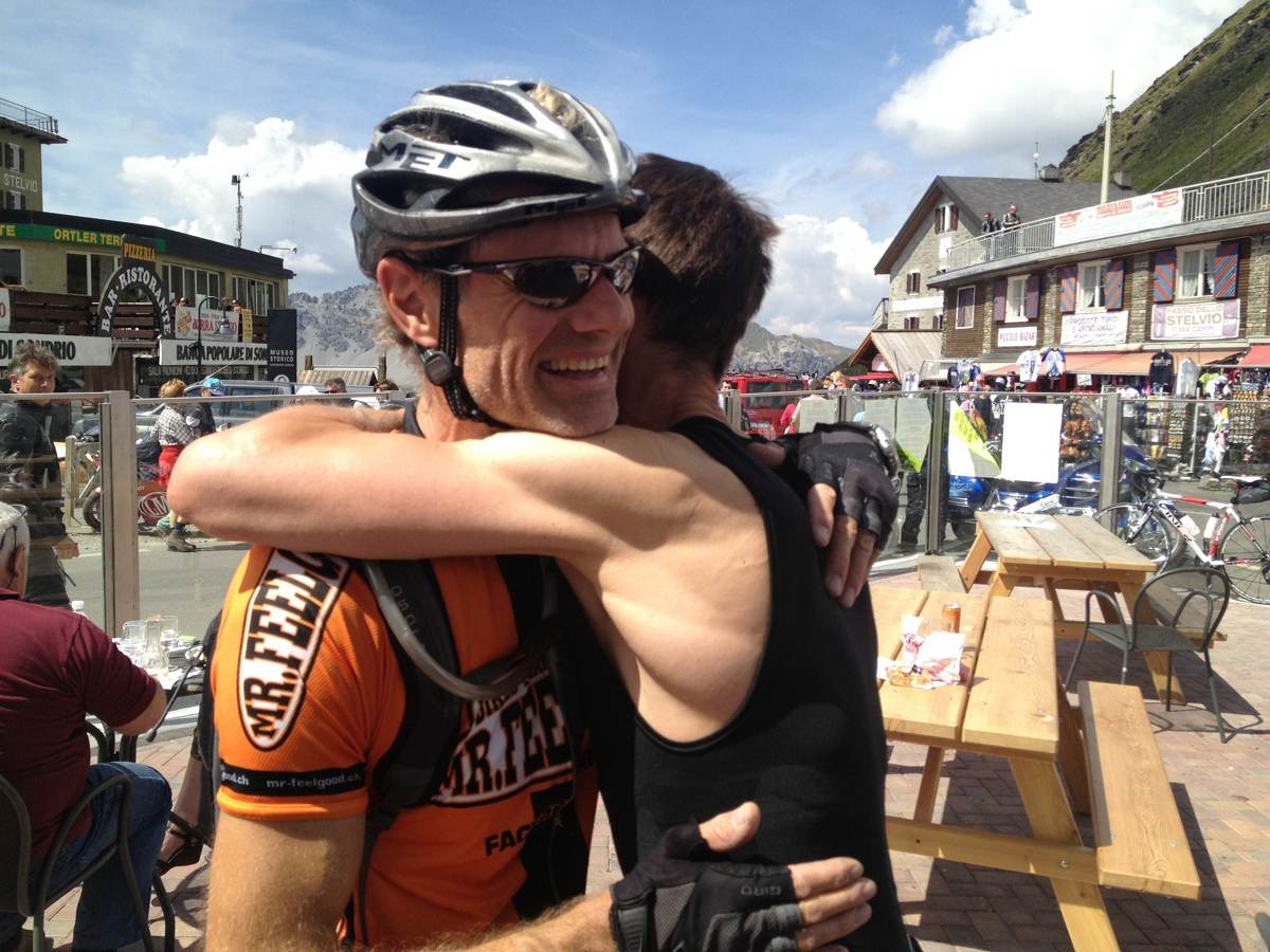 Kevin celebrating with a riding companion at the summit of the Stelvio Pass