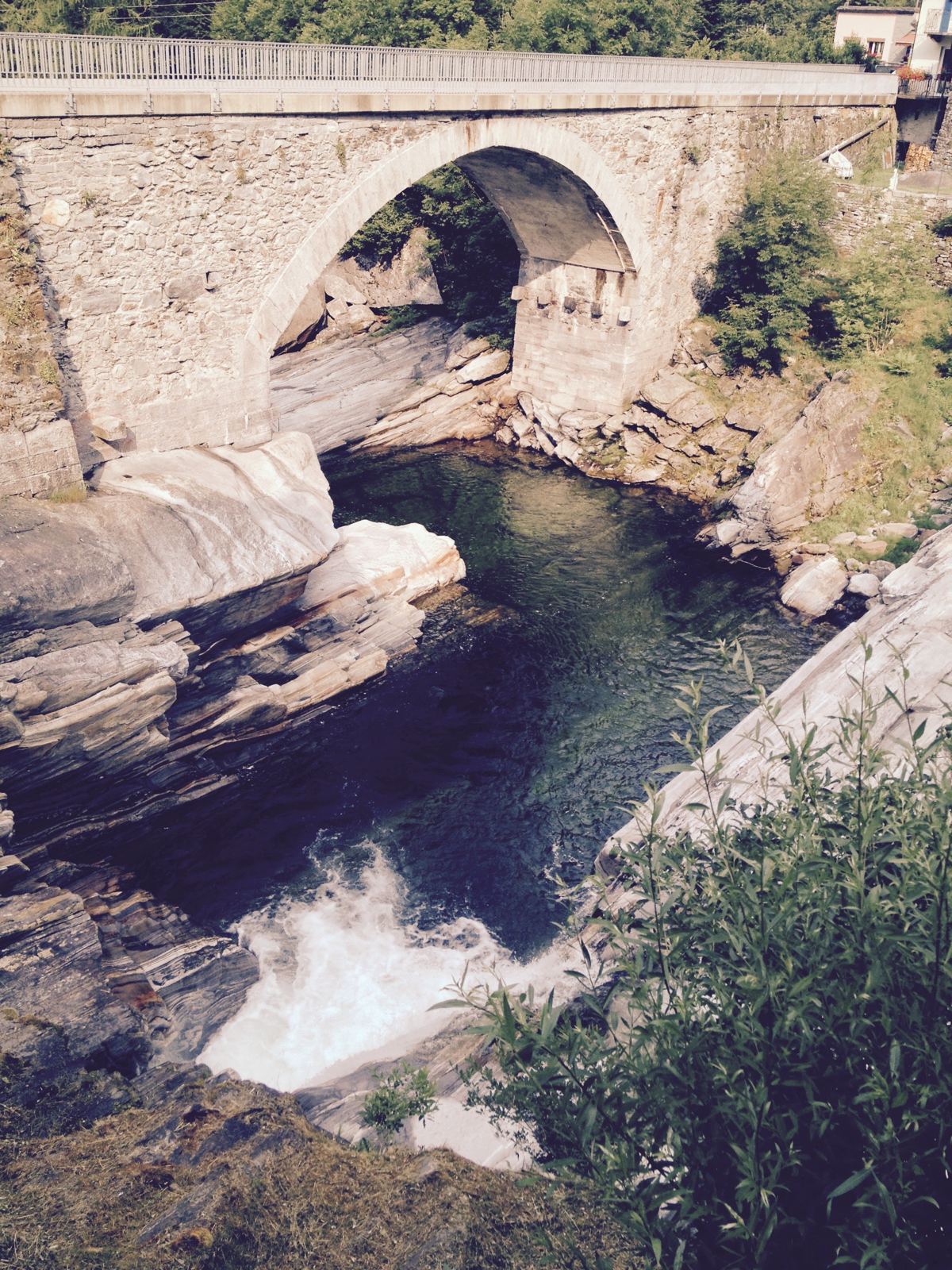 The Ponte dei Salti stone arch bridge over the emerald Verzasca river at Lavertezzo
