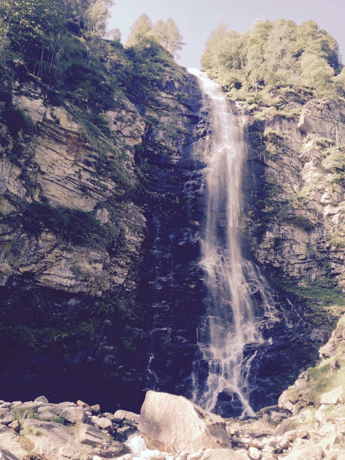 A tall waterfall dropping down a rock face near Sonogno in the Verzasca Valley