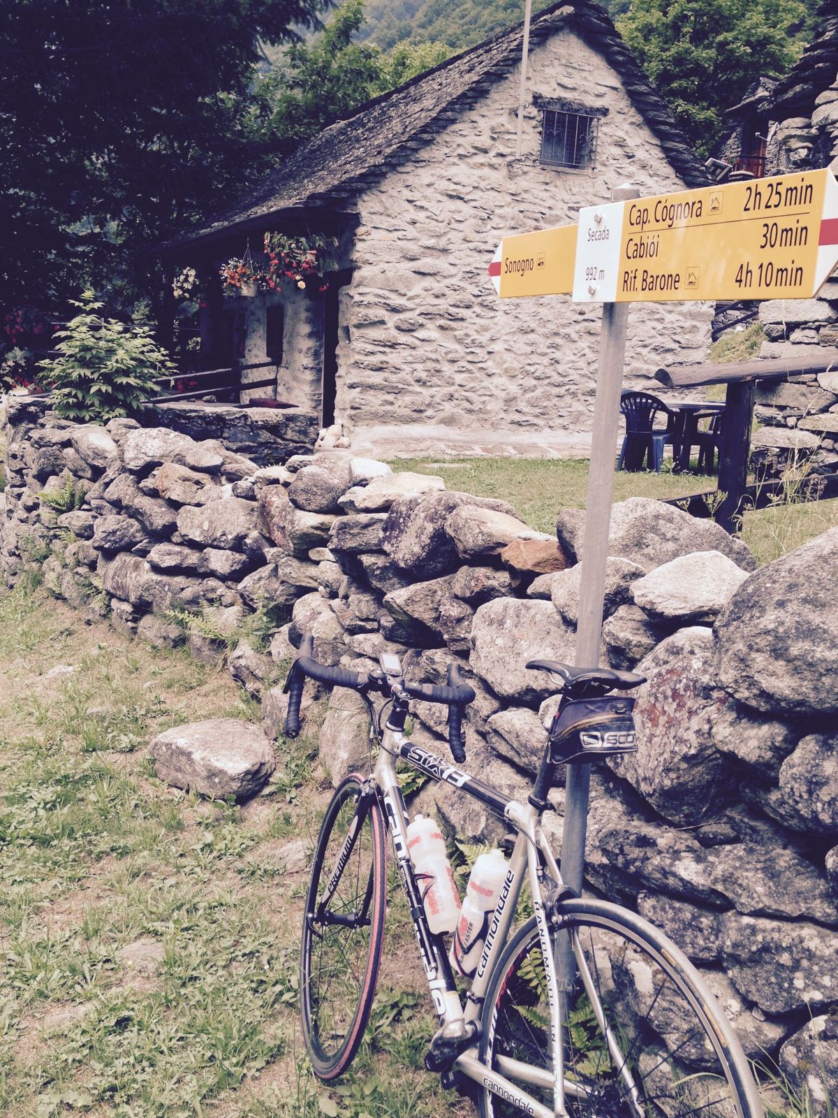 A road bike beside a hiking trail signpost at Secada, just beyond Sonogno in the Verzasca Valley